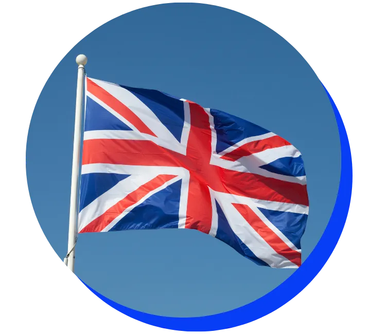 British flag (Union Jack) waving against a clear blue sky. The flag features red and white crosses on a blue background, enclosed in a circular frame with a blue border.